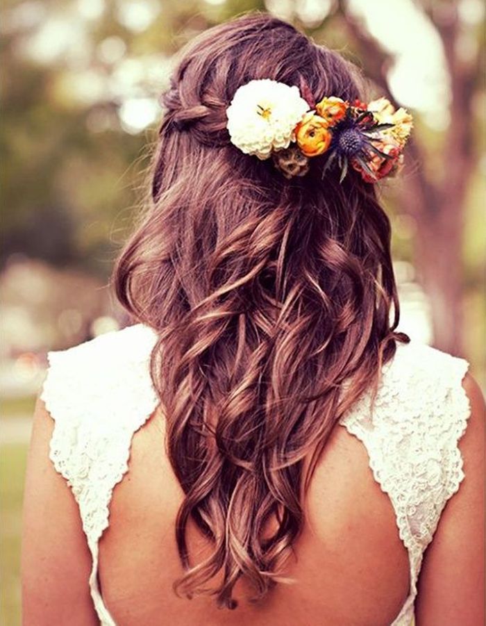 Des fleurs dans des cheveux tressés Des fleurs dans les cheveux pour un mariage bohème Elle
