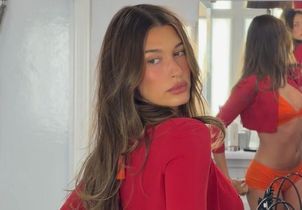 Avec son maillot de bain orange et son cardigan rouge, Hailey Bieber relance la tendance la plus audacieuse de l’été