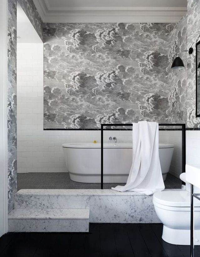 Une salle de bains grise avec papier peint
