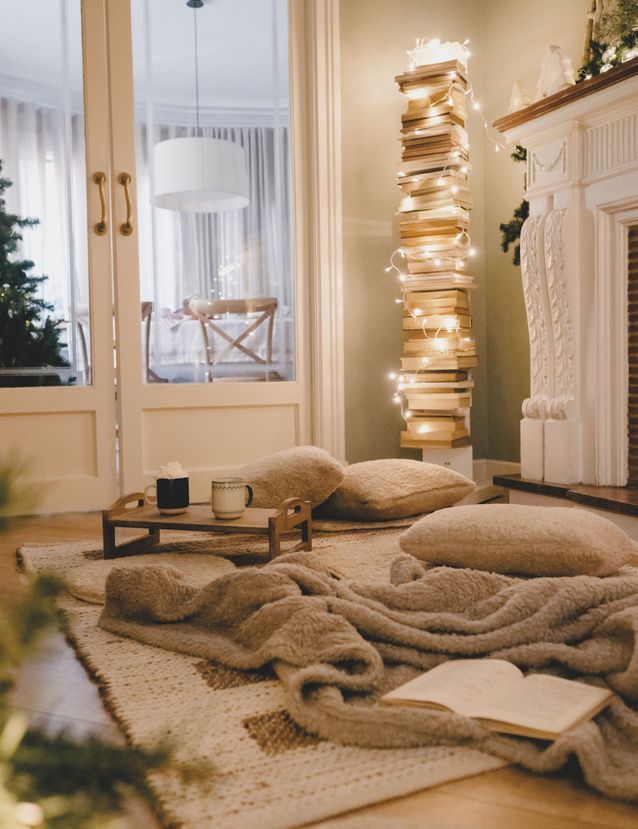 Noël : on décore la maison avec une guirlande lumineuse autour d'une pile de livres