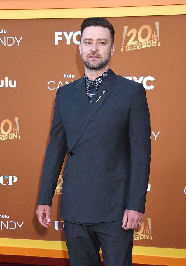 Justin Timberlake portait un costume noir et une chemise imprimée