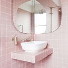 Une salle de bains rose entièrement carrelée