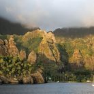 La baie de Hatiheu ses gigantesques parois rocheuses, sur lesquelles une statue de la Vierge a été érigée.